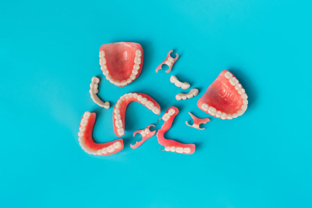 Dental prosthetics on a blue background. Dentures. Prosthetic teeth. False teeth. Prosthetic dentistry. Set of dentures on a blue background. Top view of complete denture on blue background