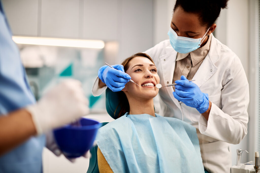 Young smiling woman having a dental exam and checkup at a dentist's office